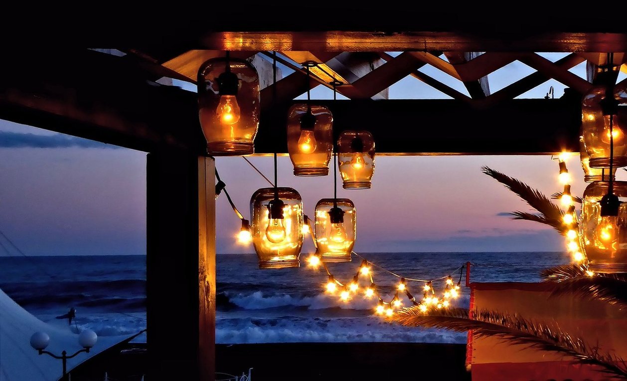 Теплого вечера на улице. Ночь море ресторан. Кафе на берегу моря закат. Вечернее кафе у моря. Ночью на террасе у моря.