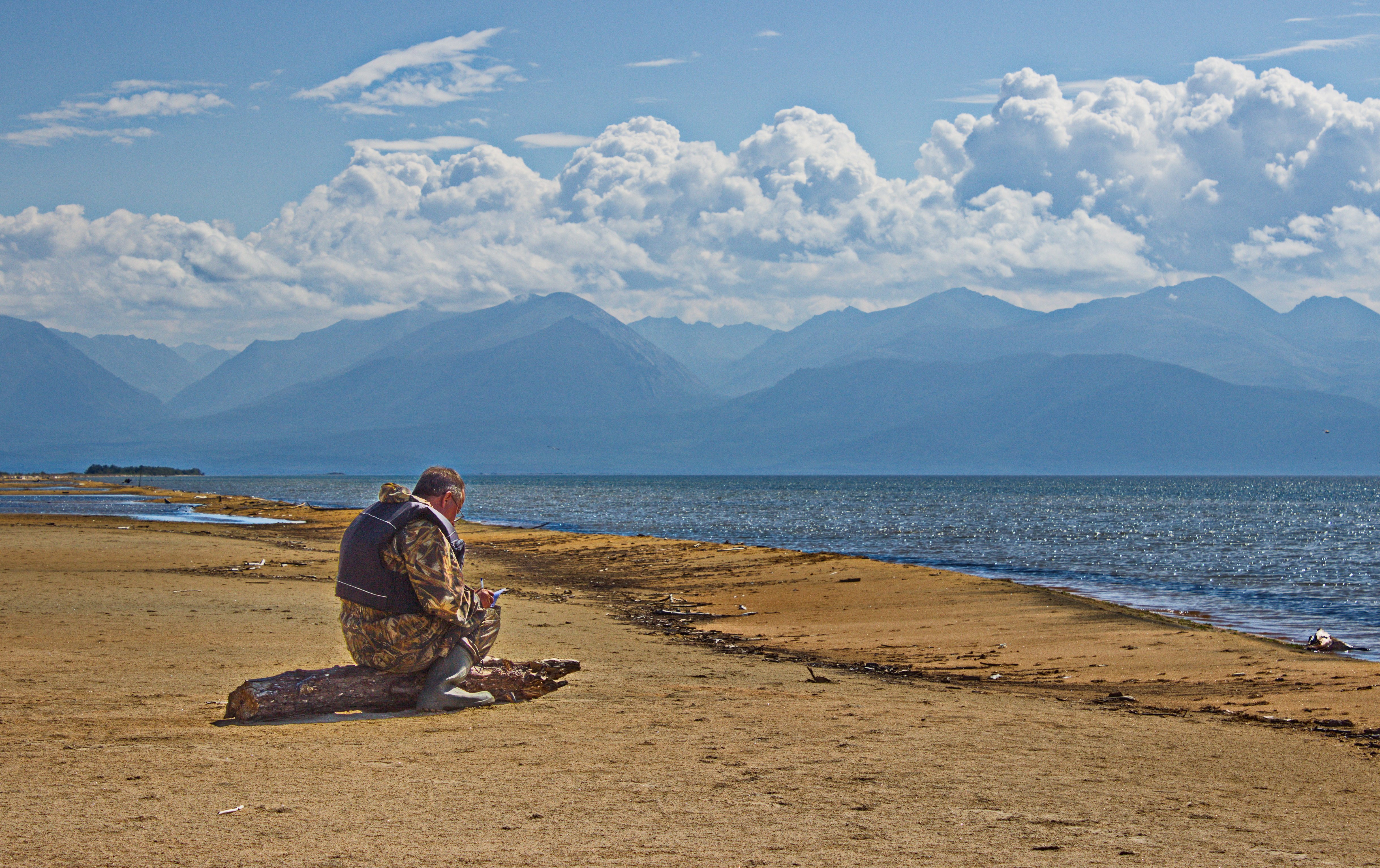 Человек молится на берегу Байкала
