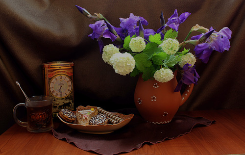 Чай,сладости и букет ирисов с цветами калины.