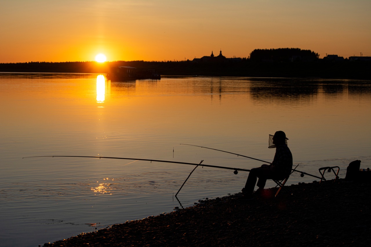 Одинокий Рыбак на реке в холодную погоду