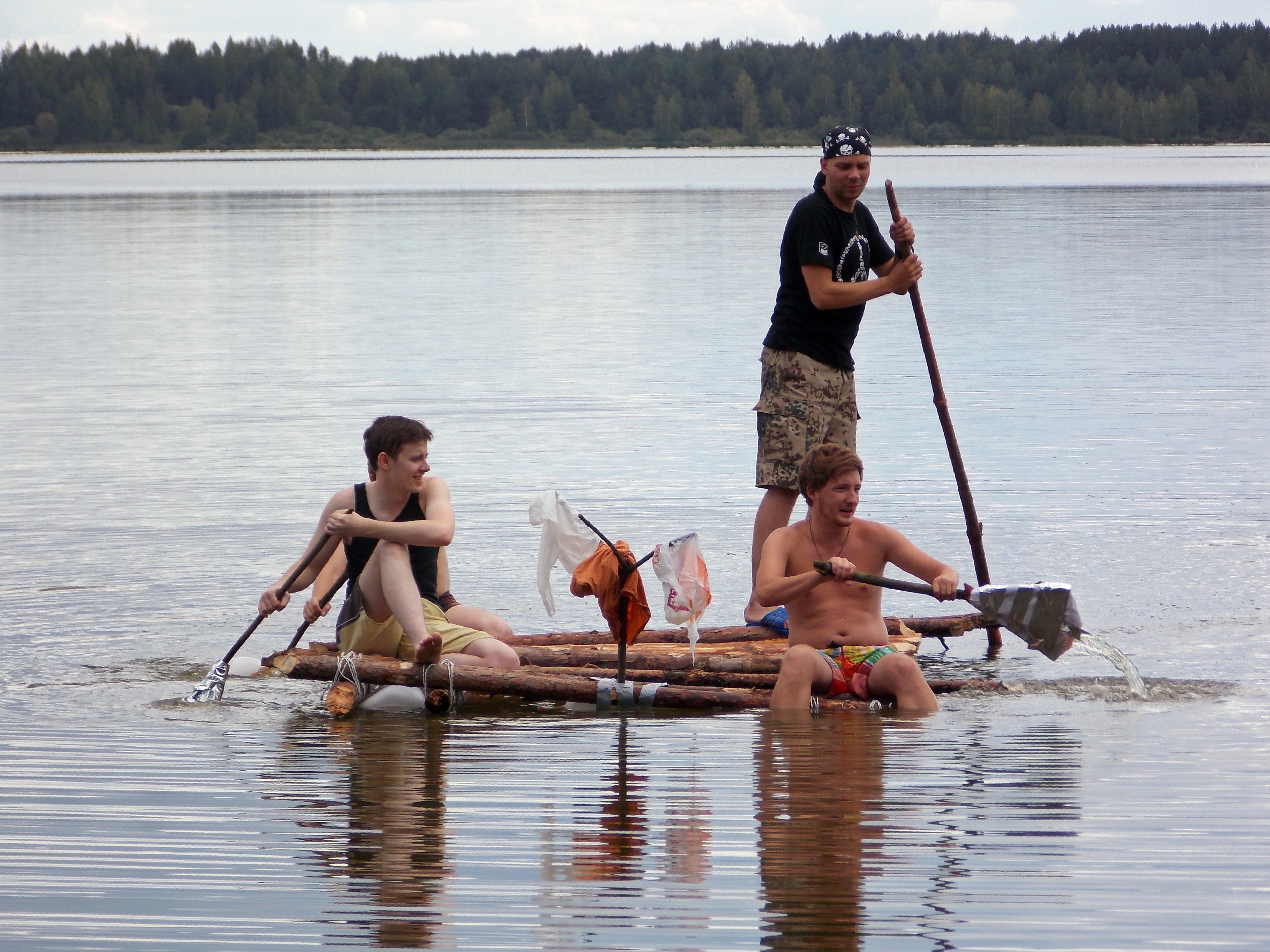 Туристы плыли по озеру на лодке. Человек на плоту. Люди на плату. На маленьком плоту. Плот на озере.